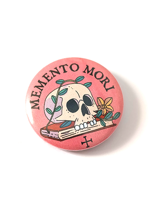 Chapa con una pequeña "Vanitas" representada con una calavera, flores y un libro. ¡Llévalas en tu bolso o chaqueta!